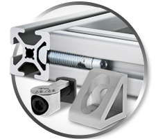 Close-up of T-slot aluminum profile with modular fasteners, anchor connector, and gusset bracket used to assemble customizable industrial framing systems.