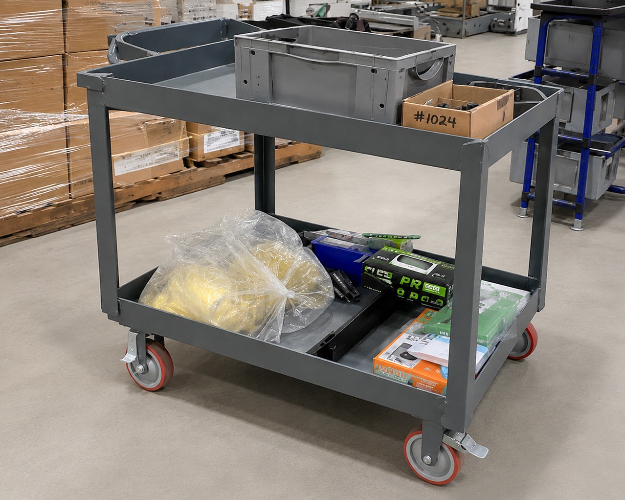 Traditional welded steel material handling cart with storage bins and industrial casters used for transporting parts and components in an automotive manufacturing facility.