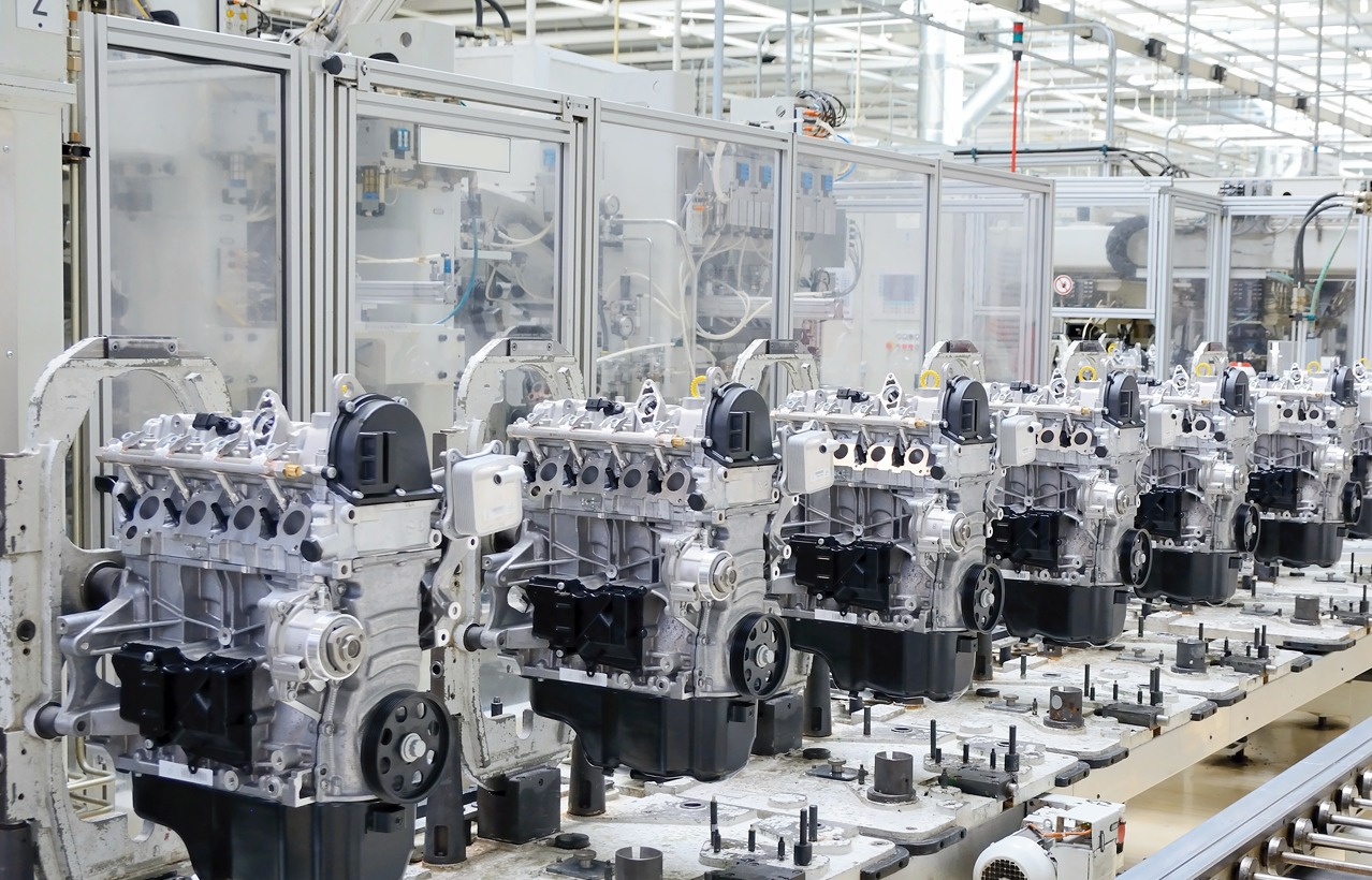 Automotive engine assembly line featuring aluminum-framed machine guarding, automated production equipment, and inline engine manufacturing for high-volume industrial production.