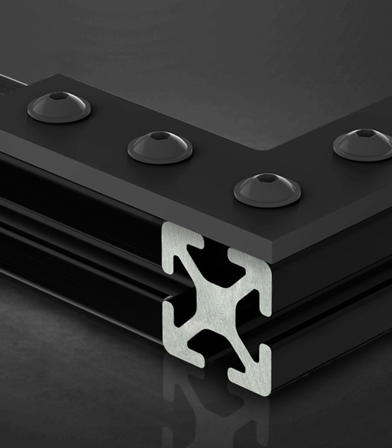 A black 80/20 Fiber Reinforced Polymer (FRP) T-slot profile assembly. The image highlights the cross-section of the non-conductive fiberglass and polyurethane resin material, joined by a heavy-duty black corner plate and mounting bolts.