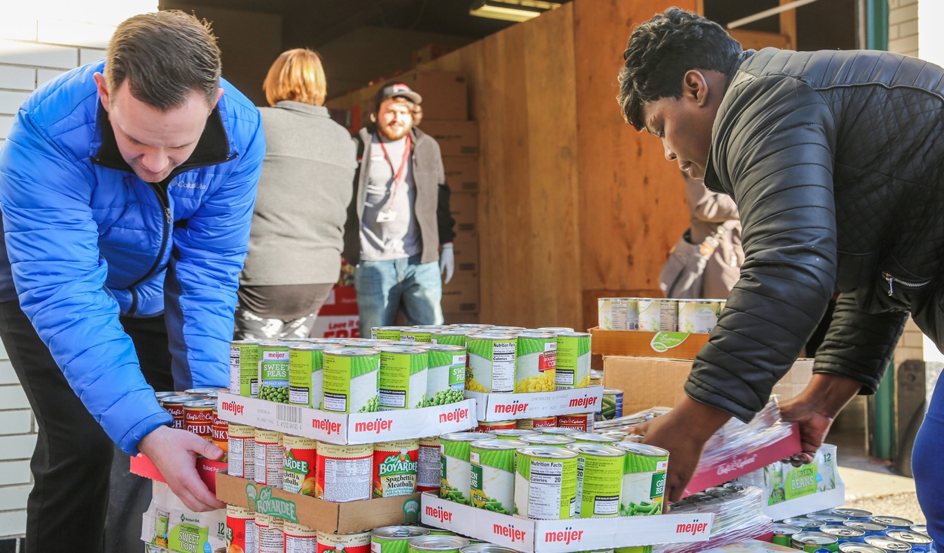 Community Volunteers Sorting Food Donations at Local Food Drive Volunteers organizing and sorting canned food donations at a community food drive to support local families and food assistance programs.