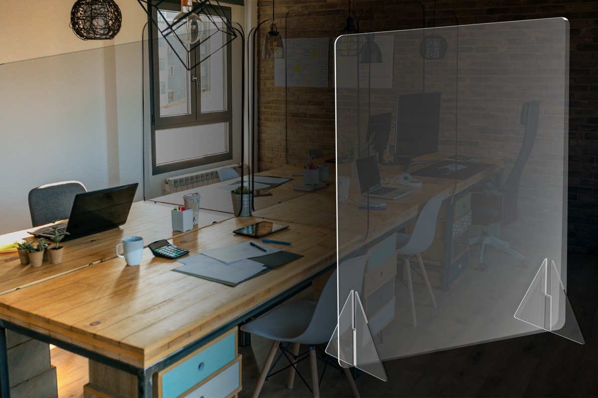Acrylic desk sneeze guard placed on an office conference table for workplace safety and separation