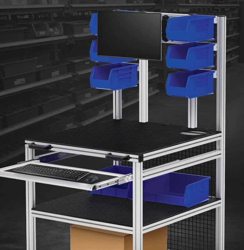 Material handling workstation featuring overhead storage bins, monitor mount, keyboard tray, and aluminum extrusion framing for inventory management, order fulfillment, and production support.