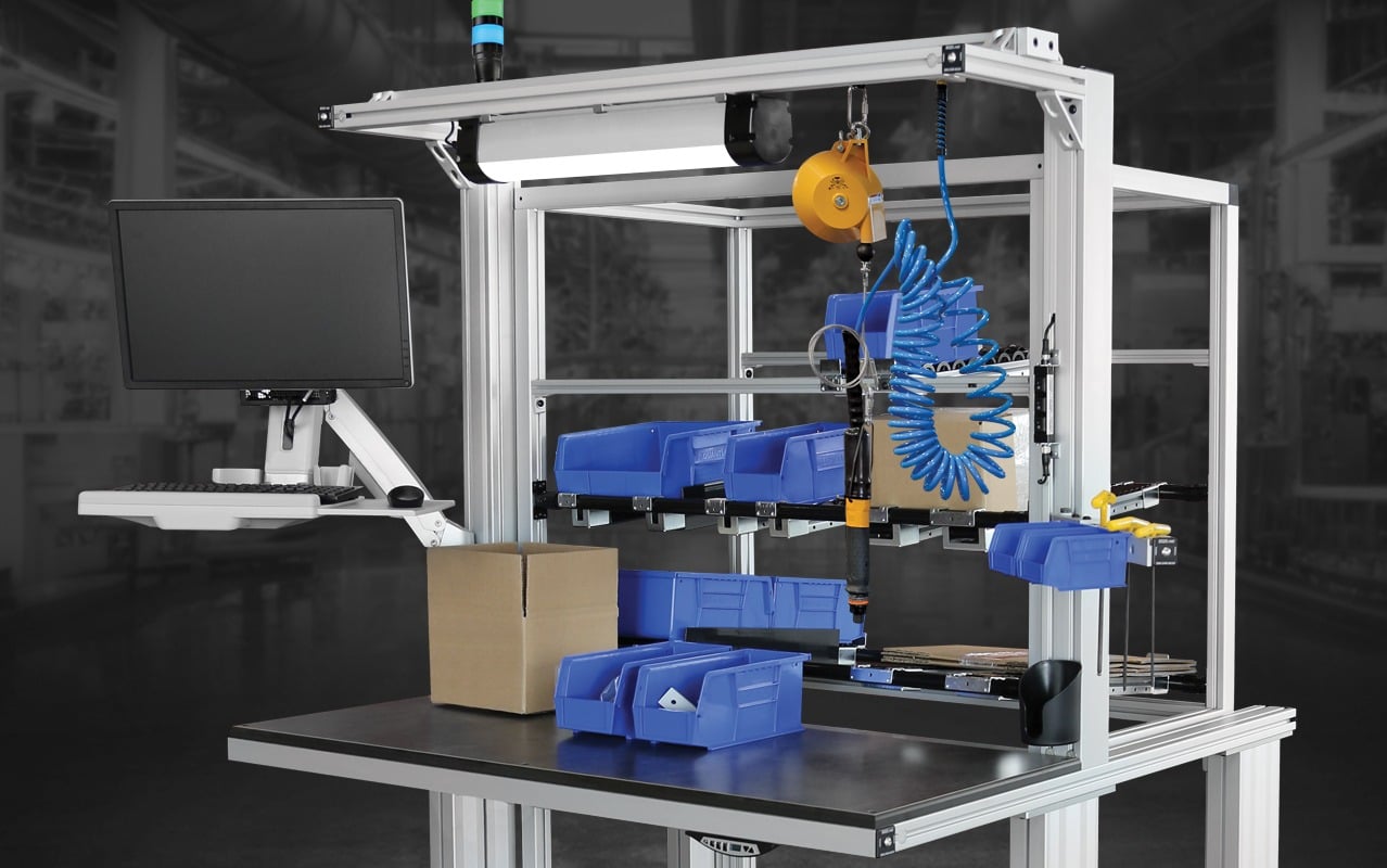 Industrial assembly workstation featuring parts bins, monitor mount, tool balancer, pneumatic tools, and aluminum extrusion framing designed for efficient manufacturing, kitting, and assembly operations.