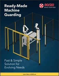 A professional 80/20 promotional graphic titled "Ready-Made Machine Guarding" featuring a 3D isometric rendering of a yellow modular safety enclosure with black wire mesh panels. The enclosure surrounds a robotic arm workstation, with a footer reading "Fa