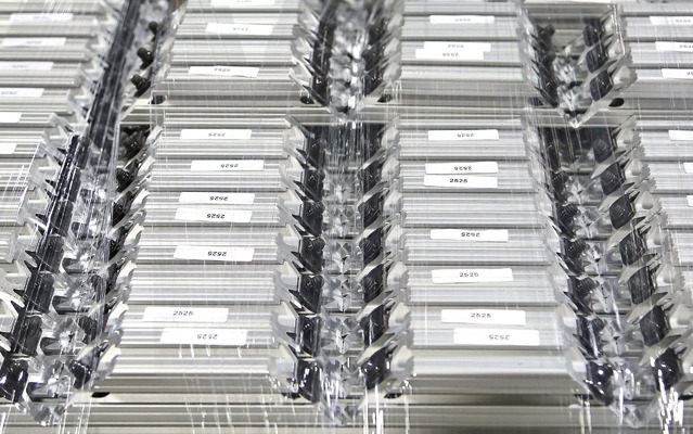 Top-down view of organized 80/20 T-slot aluminum extrusion profiles wrapped in protective clear plastic stretch film for shipping. Each silver profile is labeled and features pre-installed black fasteners, demonstrating industrial fulfillment.