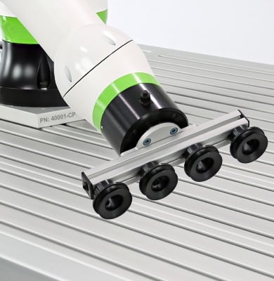 Collaborative robot arm equipped with a vacuum gripper handling materials on an aluminum extrusion workstation, demonstrating industrial automation and robotic material handling applications.