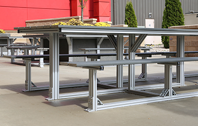 Modular aluminum workbenches in an outdoor setting, illustrating a customizable workspace solution.
