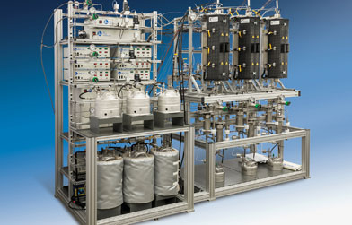 Complex industrial filtration system with multiple stainless steel vessels, piping, and control valves mounted on aluminum frames.