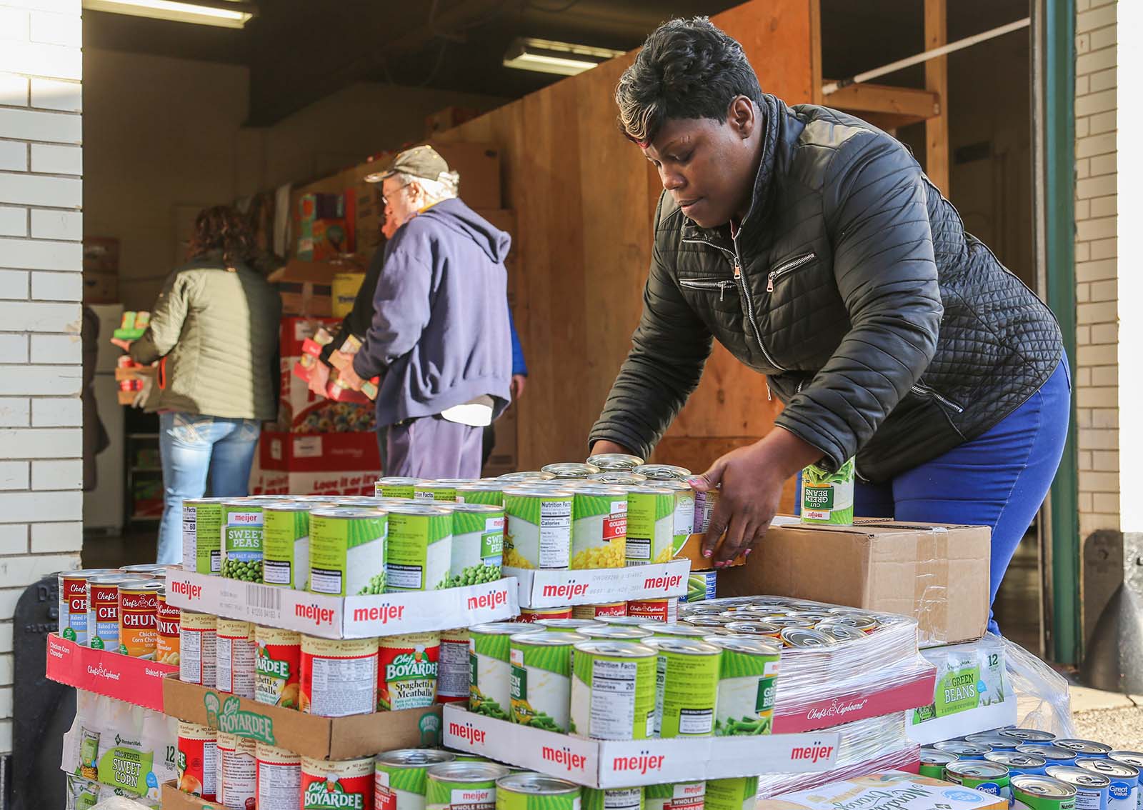 Volunteers organizing canned food donations at a community food bank.