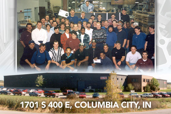 Group photo of employees in front of a company building with the address '1701 S 400 E, Columbia City, IN' displayed.