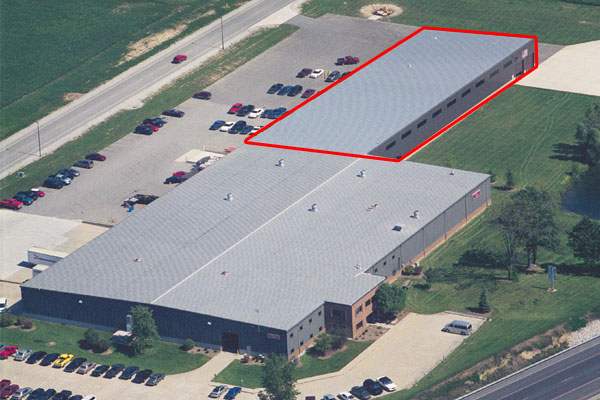 Aerial view of the 80/20 Inc. building with parking lot and a marked area on the roof for reference.