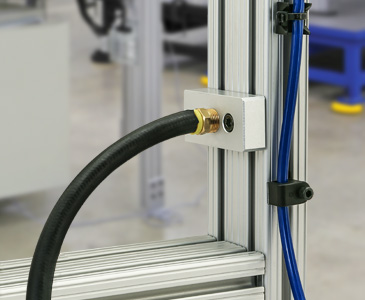 Detailed view of a cable management system with hoses and connectors attached to an aluminum extrusion frame.