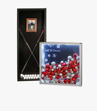 Two picture frames: one vertical black frame with golf balls and clubs arranged in an X pattern, and one horizontal frame with a 'Let It Snow' festive holiday image.