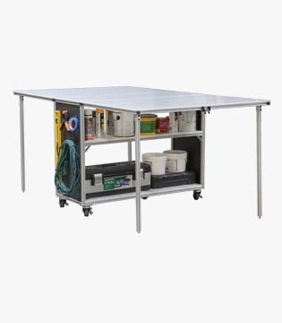 Spacious mobile folding table with metal frame, featuring under-table storage shelves stocked with various supplies and tools.