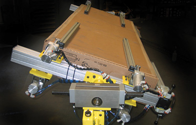 Industrial end effector with aluminum extrusions and pneumatic components, used for manipulating objects.